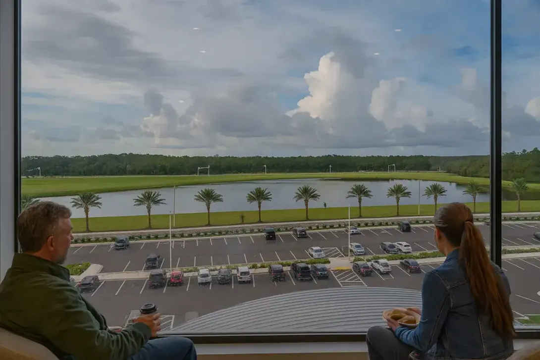 A view of the Orlando Airport parking lot and nearby lake under a cloudy sky